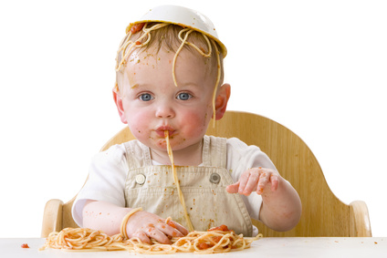 Messy baby playing with spaghetti