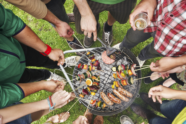 A collection of friends gathered around a bbq